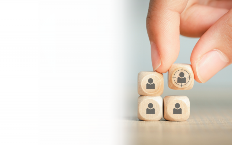 Eine Hand fügt Würfel mit Personen zusammen als Einheit. Wir bieten dazu Stellenanzeigen an um Ihr Team zu vervollständigen.